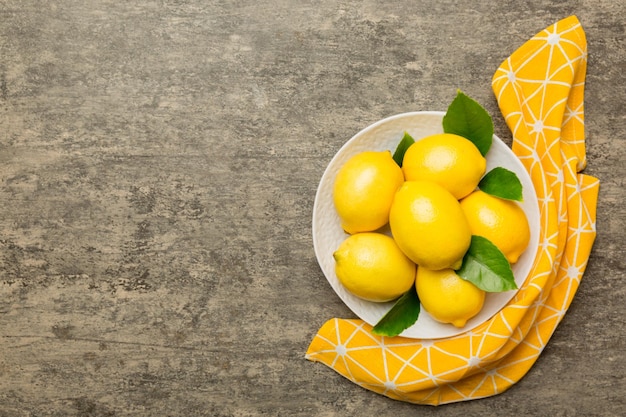 Limone fresco tagliato e limoni interi su piastra rotonda su sfondo colorato Ingredienti per cibi e bevande che preparano un'alimentazione sana tema vista dall'alto con spazio di copia