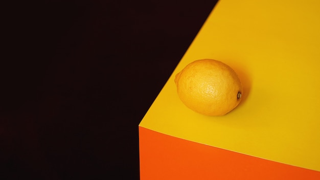 Limone giallo fresco su sfondo materiale nero e arancione