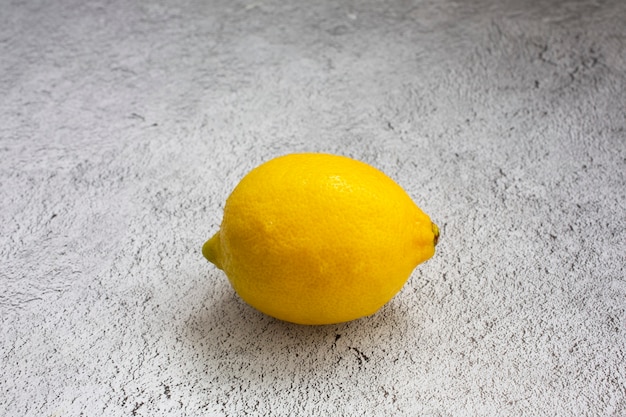 Limone giallo su un tavolo grigio.