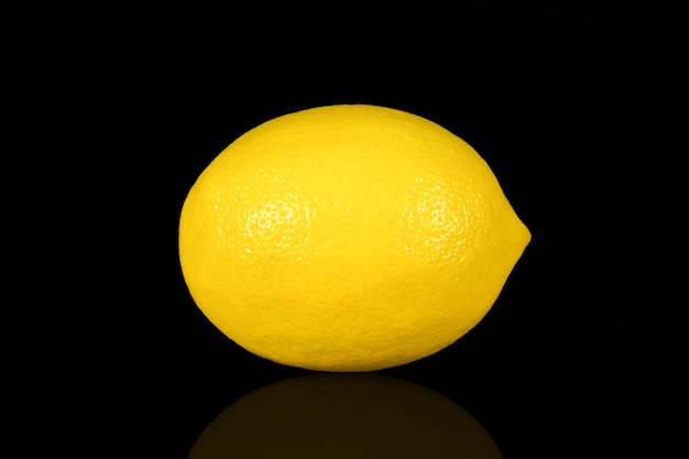 Limone maturo fresco isolato su uno sfondo nero primo piano
