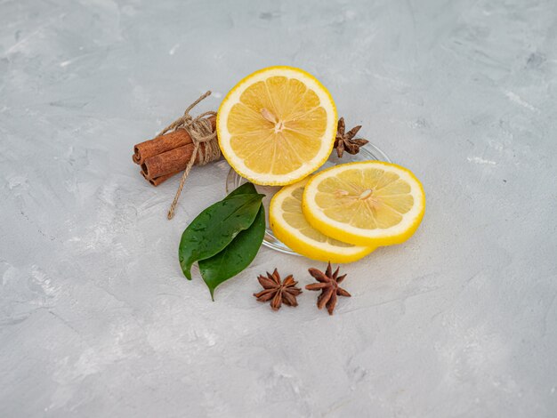 Limone tagliato con fettine di limone su una superficie, decorato con foglie di limone.