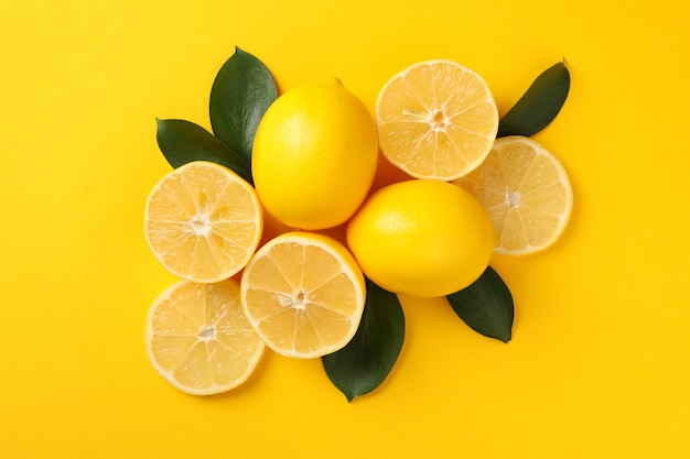 Limoni e foglie succosi su fondo giallo, vista superiore