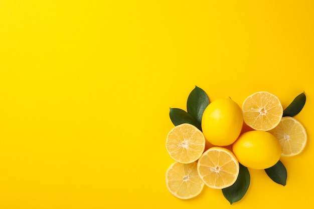 Limoni e foglie succosi su fondo giallo, vista superiore