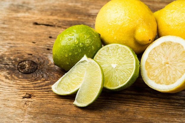 Limoni e lime freschi e succosi su una superficie di legno