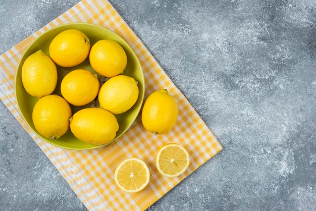 Limoni in ciotola su sfondo grigio