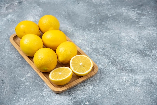 Limoni in scatola di legno su fondo grigio