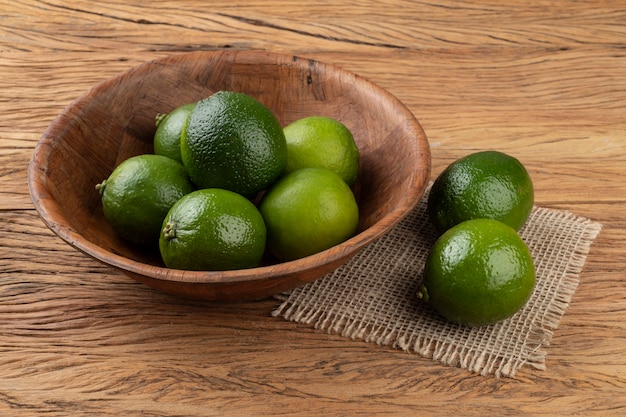 Limoni in una ciotola su un tavolo di legno.