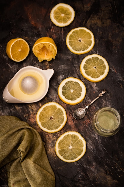 Limoni maturi affettati freschi con spremiagrumi e cucchiaio sul nero