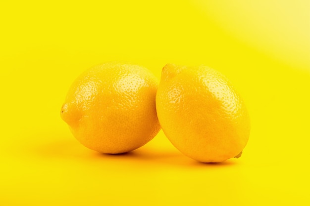 Limoni maturi freschi isolati su fondo giallo.