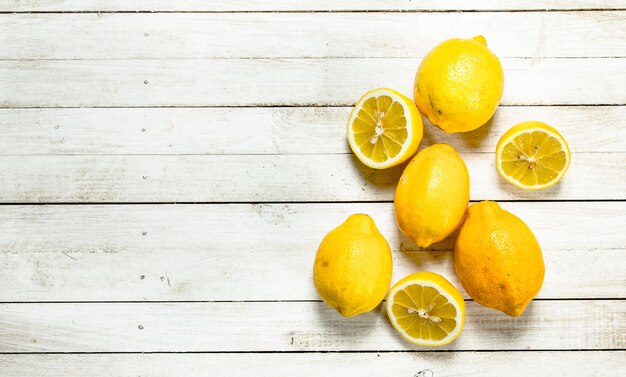 Limoni maturi freschi. Su un tavolo di legno bianco.