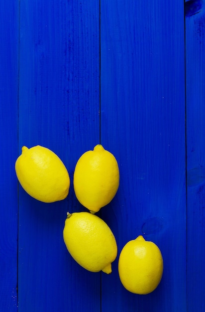 Limoni multipli su sfondo di legno blu con spazio negativo per la copia