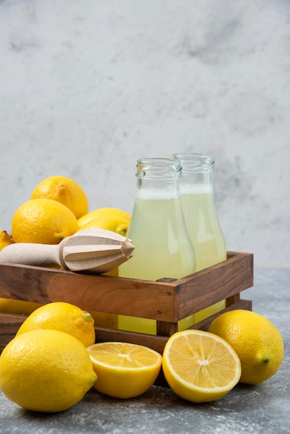 Limoni sfondo grigio succo di limone e fresco sul tagliere