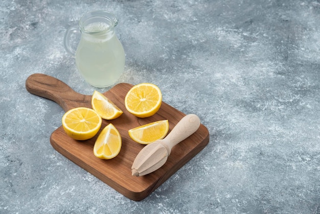 Limoni sfondo grigio succo di limone e fresco sul tagliere