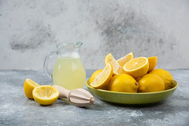 Limoni sfondo grigio succo di limone e fresco sul tagliere