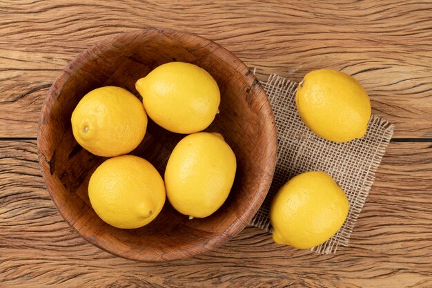 Limoni siciliani in ciotola su tavola di legno