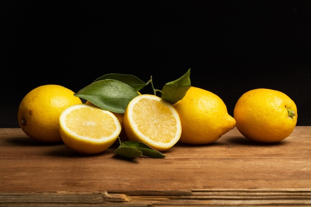 Limoni su un tavolo di legno e su uno sfondo nero