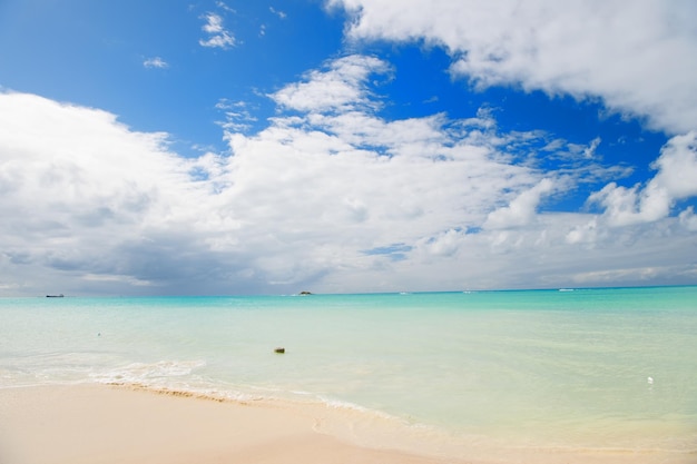 Linea costiera del Mar dei Caraibi con acqua pulita e ondulata dell'oceano sulla spiaggia sabbiosa in una giornata di sole come sfondo naturale con cielo blu, st. Giovanni, Antigua