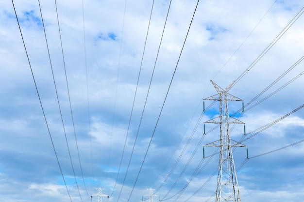 Linea della torre di tensione di altezza sui precedenti del cielo nuvoloso.