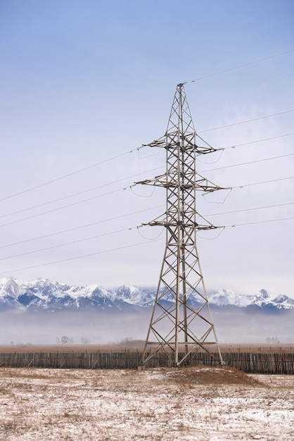 Linea elettrica nei campi sullo sfondo delle montagne