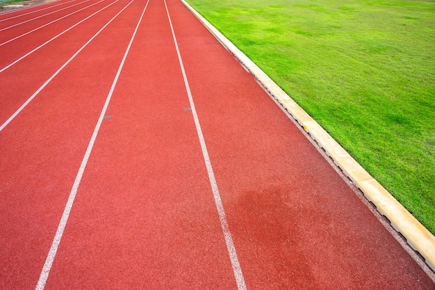 Linee bianche di stadio e struttura dei circuiti di gomma rossi della pista corrente in all&#39;aperto