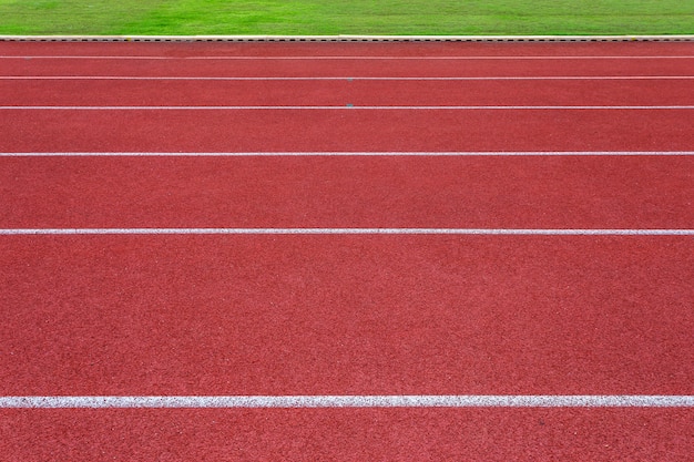 Linee bianche di stadio e struttura di piste da corsa in gomma rossa da corsa