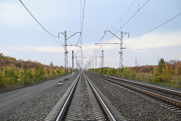 Linee elettriche ad alta tensione che passano attraverso un campo arato sullo sfondo di un bel cielo nuvoloso