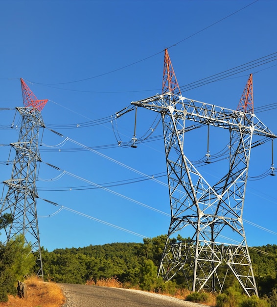 Linee elettriche ad alta tensione che passano attraverso un campo arato sullo sfondo di un bel cielo nuvoloso