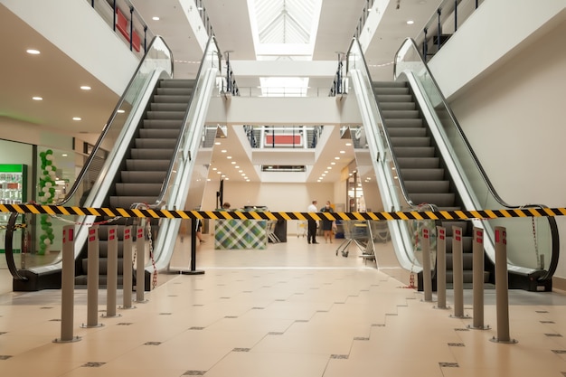 Linee nere e gialle di nastro barriera vietano l'accesso al supermercato.