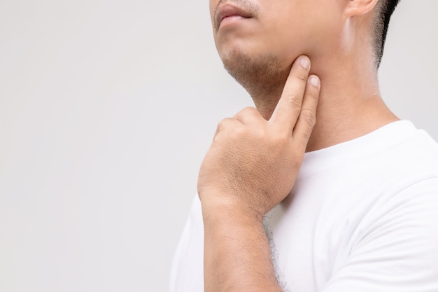 Linfoma nel concetto degli uomini: l'uomo asiatico del ritratto sta toccando il suo collo alla posizione del linfonodo.