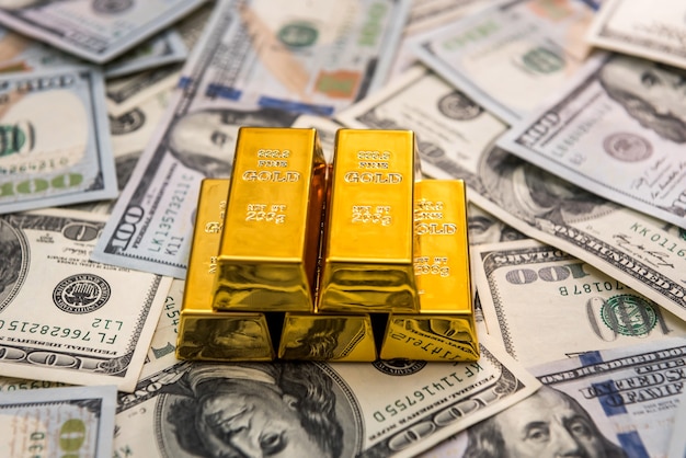 Lingotti d'oro alle banconote in dollari americani da vicino