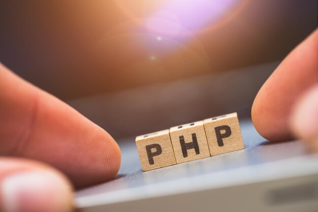 Linguaggio web di programmazione PHP Cubi di legno con lettere PHP che si trovano su un concetto di laptop