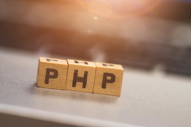 Linguaggio web di programmazione PHP Cubi di legno con lettere PHP che si trovano su un concetto di laptop