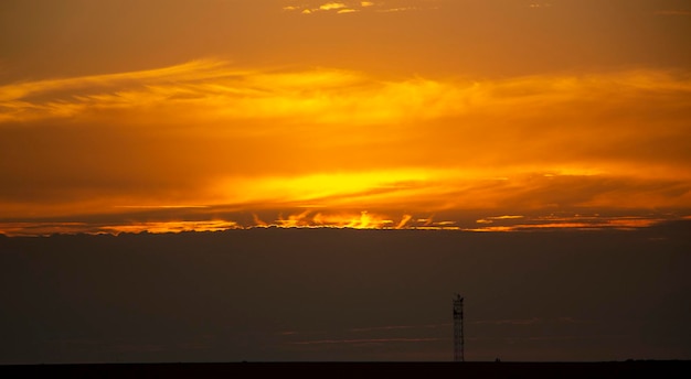 Lingue di fuoco da dietro le nuvole al tramonto bellissimo tramonto rosso dietro le nuvole