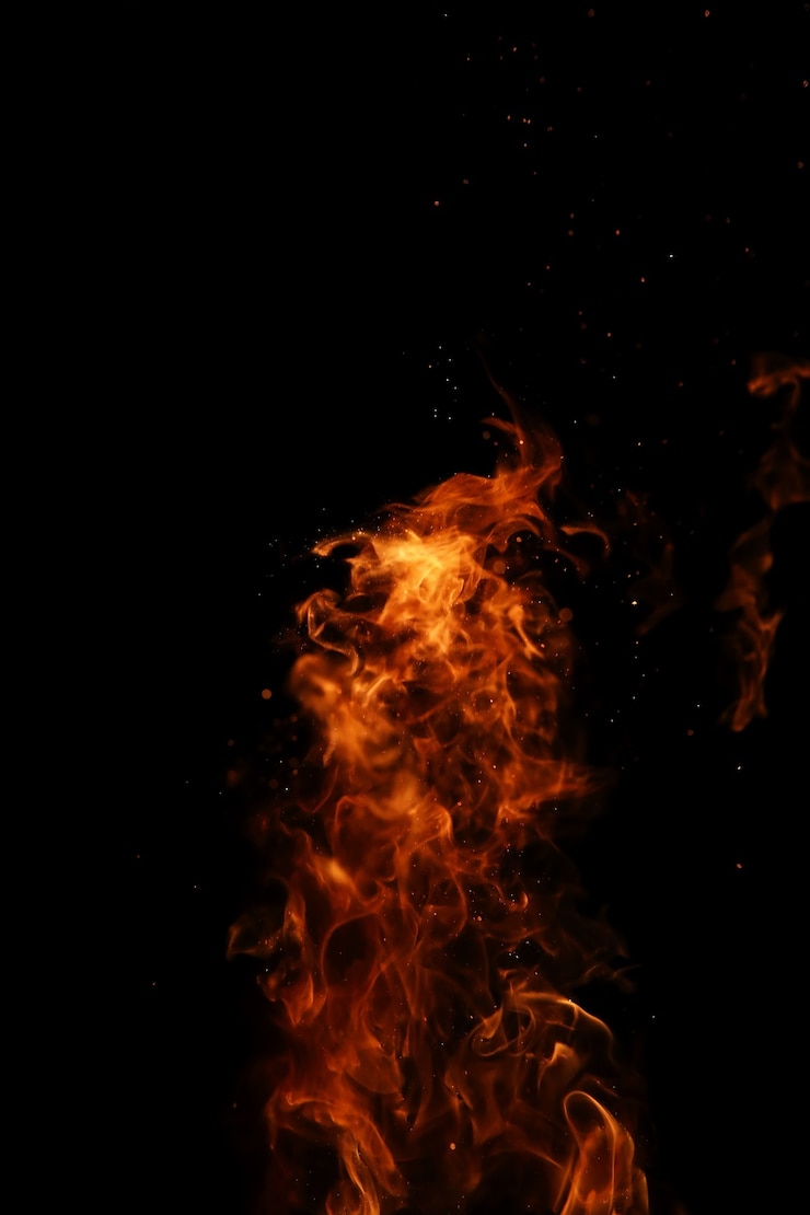 Foto lingue di una fiamma di fuoco di colore giallo-arancio dalla combustione di legna da ardere