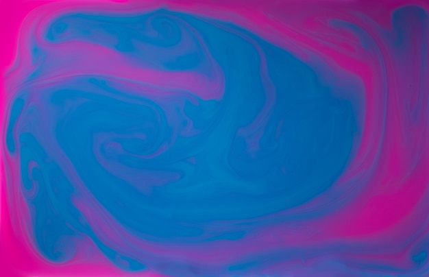 Liquidi blu e Pinkk mescolati insieme in un fluido che crea uno sfondo astratto colorato