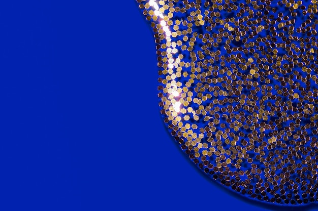 Liquido trasparente con glitter oro che si riversa su uno sfondo festoso sfondo blu per il tuo progetto