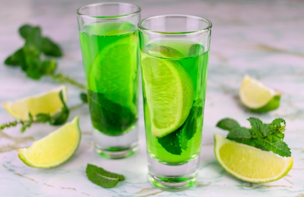 Liquore alcolico alla menta e lime in bicchieri bassi.