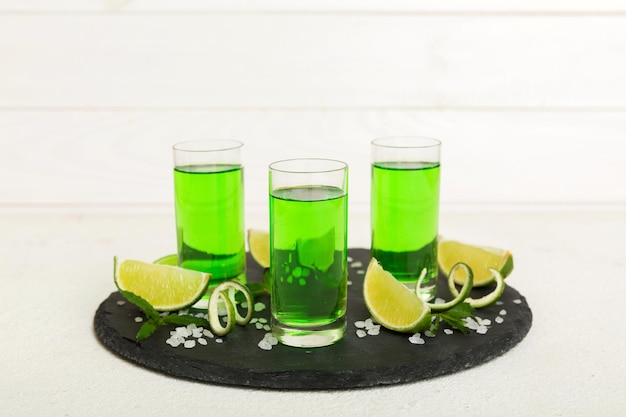 Liquore alla menta dolce e rinfrescante con ghiaccio e foglie di menta sullo sfondo del tavolo Scatti con fetta di lime e menta piatta