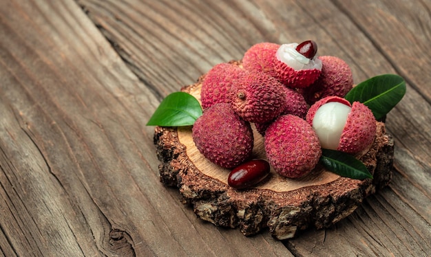 Litchi maturi Frutti asiatici esotici in ciotola su piatto su sfondo di legno Vista dall'alto in formato banner lungo