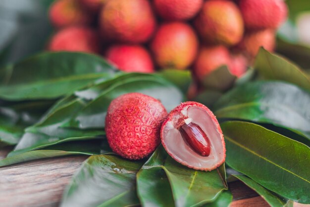 Litchi organici freschi di frutta e foglie di litchi su un rustico di legno