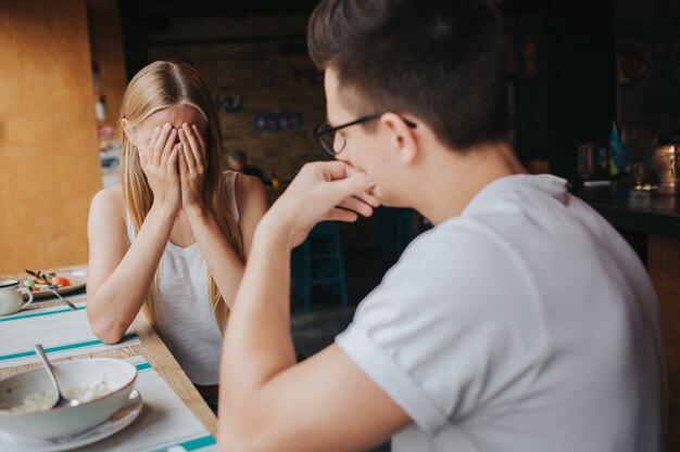 Litigare tra due giovani in una caffetteria, in un bar o in un ristorante