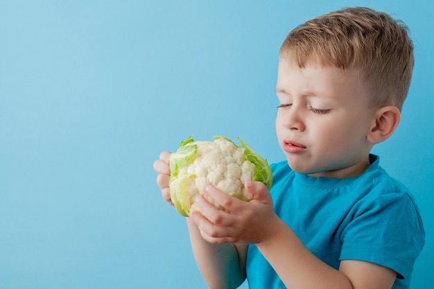 Little Boy Holding Broccoli nelle sue mani, dieta ed esercizio fisico per un buon concetto di salute.