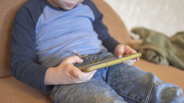 Little Boy usa il telefono per giocare o imparare a stare a casa