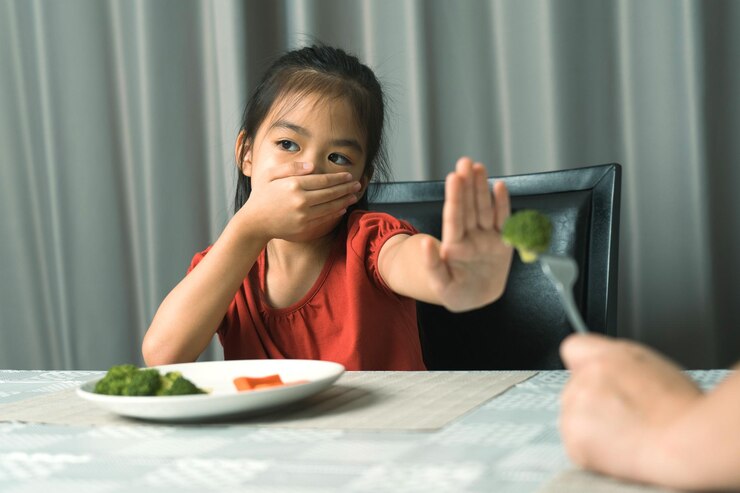 Little cute kid girl refusing to eat healthy vegetables Children do not like to eat vegetables