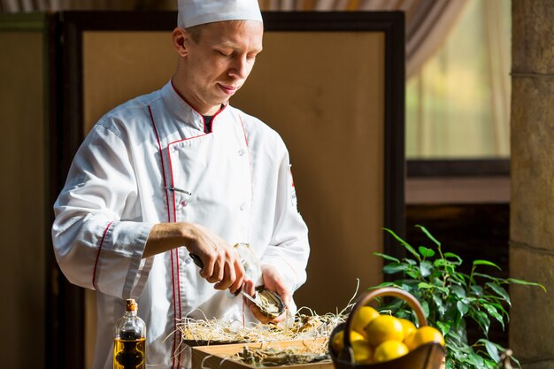 Lo chef apre ostriche fresche in un ristorante