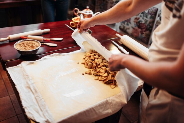 Lo chef avvolge il ripieno in pasta, strudel di mele