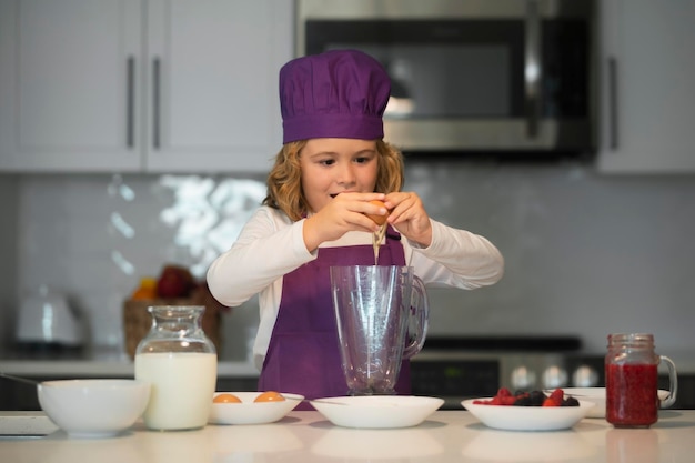 Lo chef bambino che cucina i bambini sta preparando l'impasto cuocere i biscotti in cucina