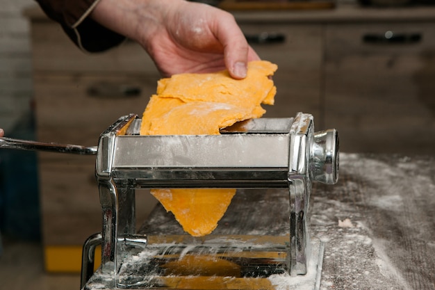 Lo chef con la macchina per la pasta fa la pasta gialla