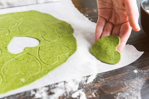 Lo chef cuoco passo dopo passo prepara i ravioli verdi a forma di cuore per una cena festiva