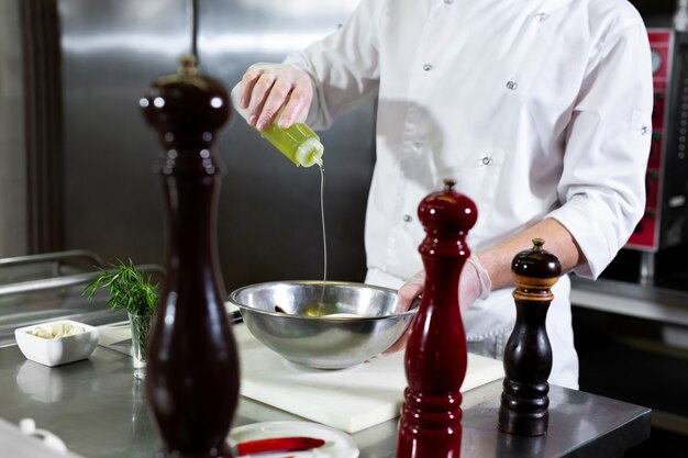 Lo chef del ristorante fa marinare i frutti di mare in una ciotola